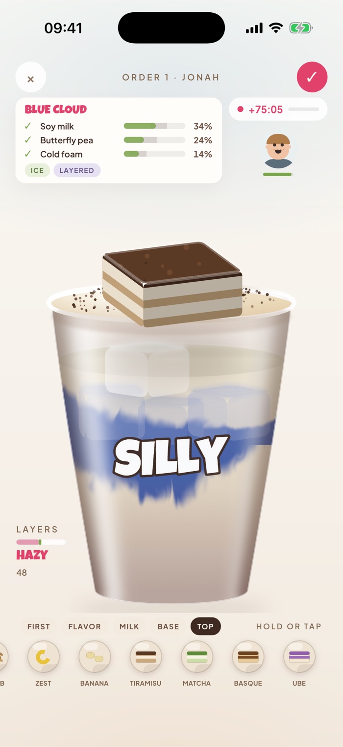 A Blue Cloud being built: soy milk, butterfly pea and cold foam over ice, dusted with cocoa, with a slice of tiramisu on the rim.